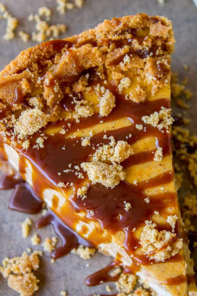 a slice of pumpkin cheesecake with caramel sauce and graham cracker crumbles.