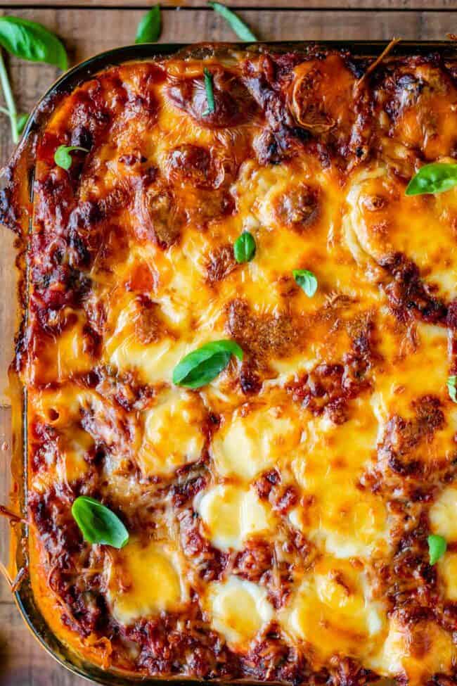 The Best Baked Ziti from The Food Charlatan. This recipe is a favorite! Italian sausage marinara, cottage cheese, and fresh basil combine to make this decadent casserole. The best part is the mozzarella that's chopped instead of shredded. They melt into pools of cheesy glory. We've always called it "Postpartum Ziti" because it makes a TON and is perfect for bringing to new moms! #bakedziti #pasta #ziti #easy #recipe #marinara #italiansausage #best #foracrowd #classic #cheesy #mozzarella baked ziti with sausage shot from above.