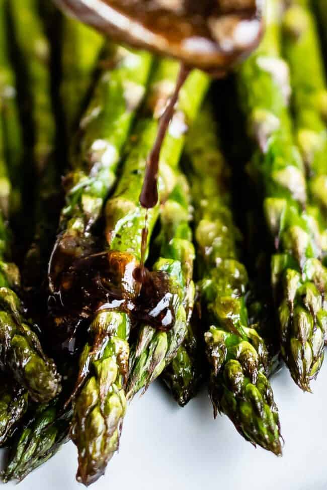 Close-up of roasted asparagus on a white plate. 
