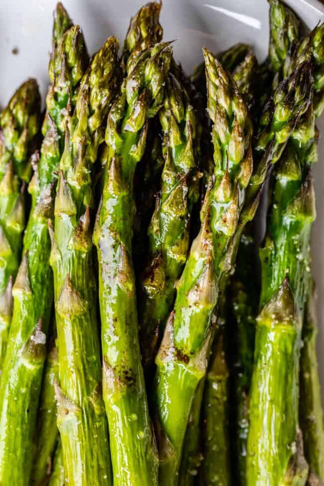 roasted asparagus on a white plate. 