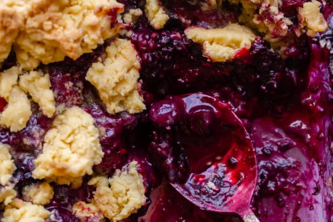 frozen berry cobbler after baking with a metal spoon.