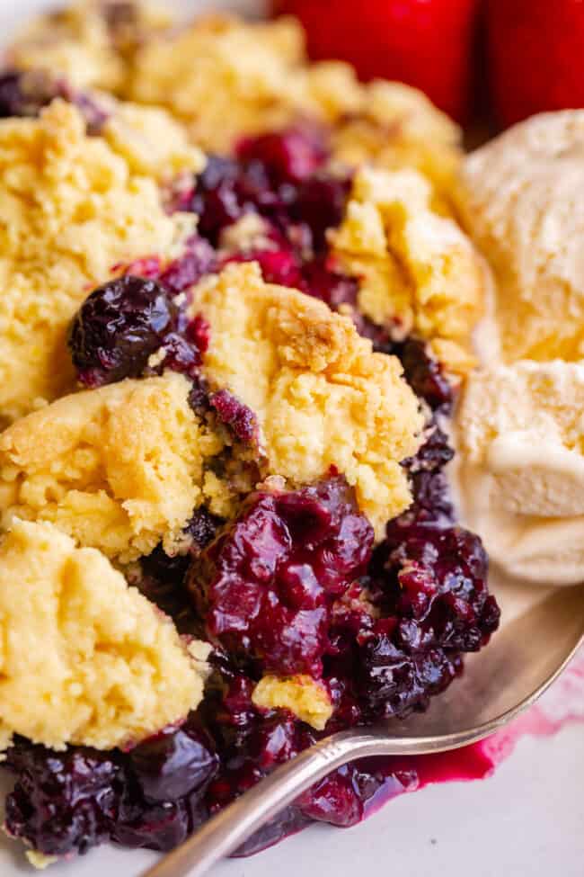 mixed berry cobbler recipe on a plate with ice cream.