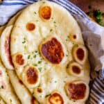 how to make naan bread, stacked on a blue napkin