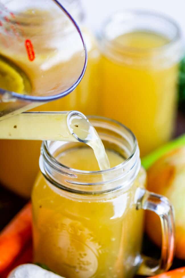 turkey stock poured from measuring cup into quart-sized Mason jar.