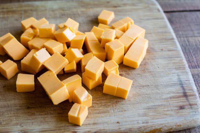 cubes of Velveeta cheese on a cutting board.