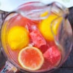 overhead shot of watermelon lemonade in pitcher on wood table.