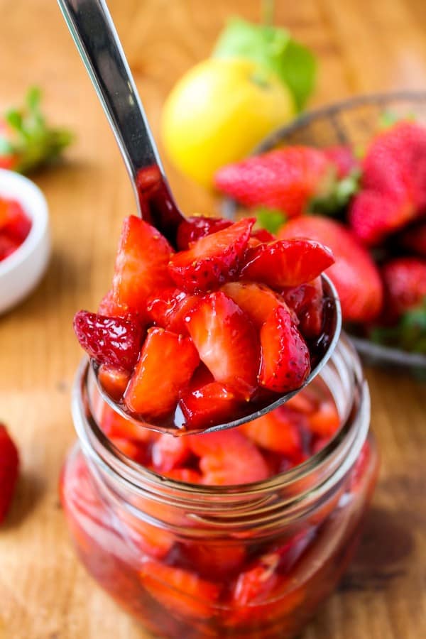 Fresh Strawberry Topping in a mason jar with a spoon.