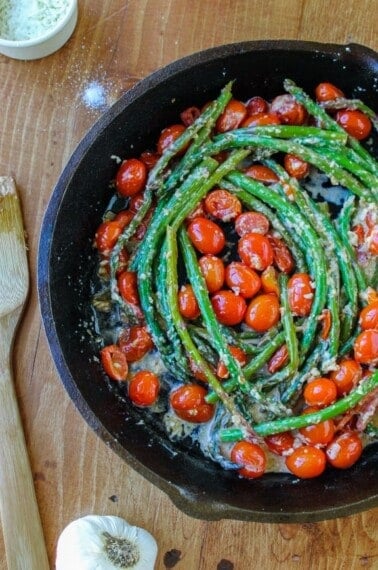 asparagus and cherry tomatoes in a cast iron skillet.