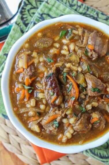 beef and barley soup in a white bowl.