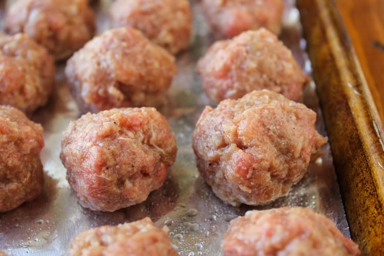 Easy Baked Meatballs from The Food Charlatan. These easy baked meatballs are perfect for making ahead and freezing! They are no-chop, homemade, and very easy to adapt. Skip the overpriced frozen ones at the store! #meatballs #baked #easy #homemade #beef #simple #forspaghetti homemade meatballs ready to be baked in the oven.