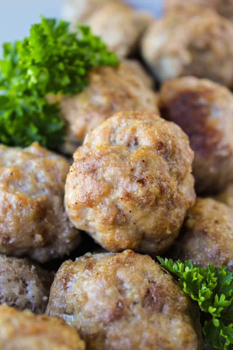 Easy Baked Meatballs from The Food Charlatan. These easy baked meatballs are perfect for making ahead and freezing! They are no-chop, homemade, and very easy to adapt. Skip the overpriced frozen ones at the store! #meatballs #baked #easy #homemade #beef #simple #forspaghetti baked meatballs with parsley garnish.