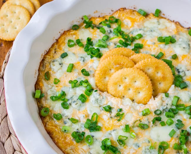 buffalo chicken dip with green onions and crackers.