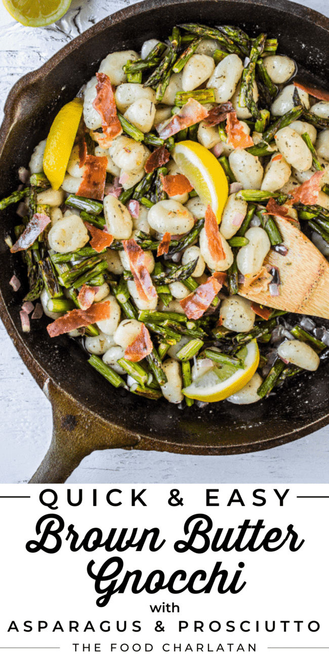 a cast iron skillet with gnocchi, asparagus, lemon slices, and a wooden spoon.