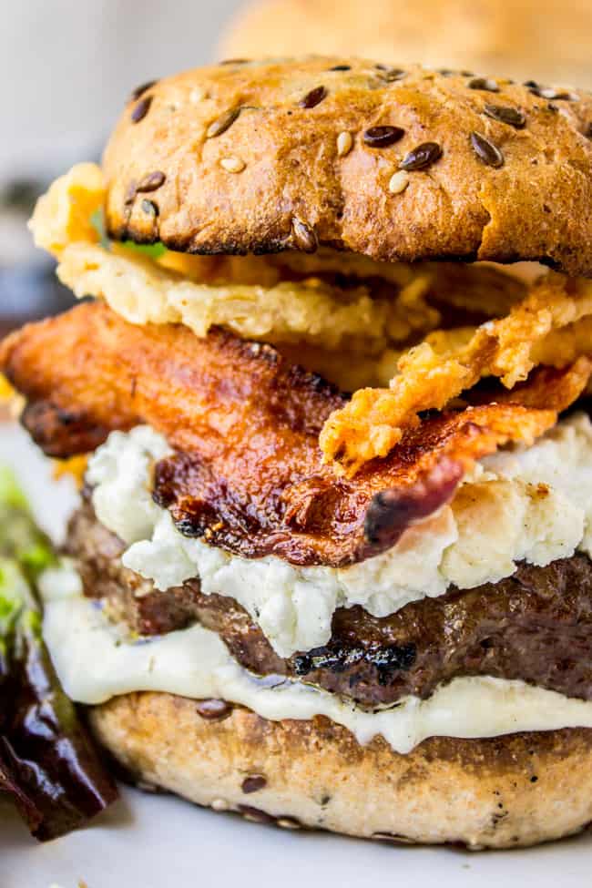 Bacon and Goat Cheese Aioli Burger with Crispy Onions from The Food Charlatan. This juicy lemon aioli burger is topped with goat cheese, bacon, crispy onion strings, and a killer bun. It's a gourmet burger recipe that's perfect for any summer grilling get-togethers! #burger #aioli #grill #bacon #crispyonions #goatcheese #hamburgerbun #daveskillerbread #summer Bacon and Goat Cheese Aioli Burger