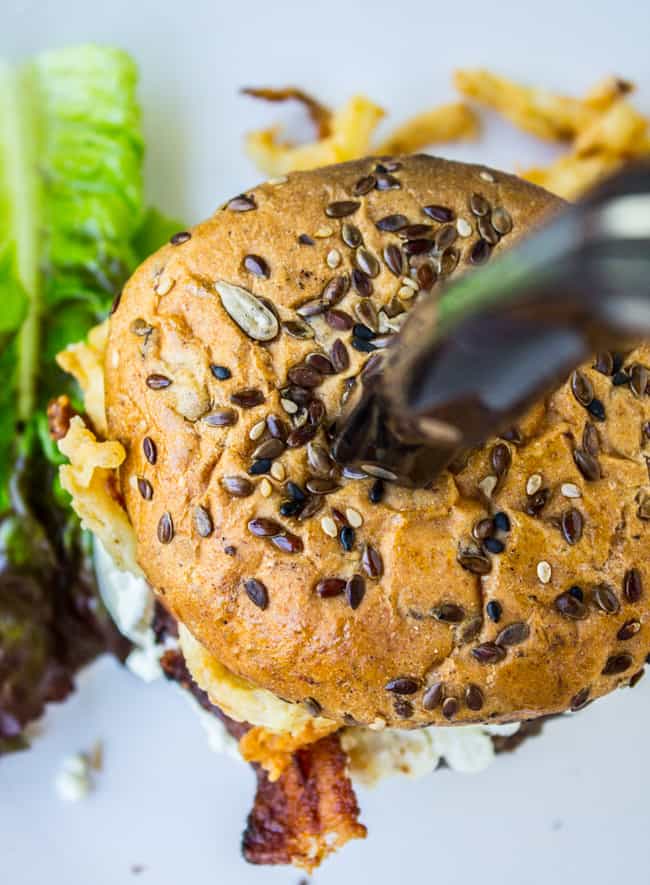 Bacon and Goat Cheese Aioli Burger with Crispy Onions from The Food Charlatan. This juicy lemon aioli burger is topped with goat cheese, bacon, crispy onion strings, and a killer bun. It's a gourmet burger recipe that's perfect for any summer grilling get-togethers! #burger #aioli #grill #bacon #crispyonions #goatcheese #hamburgerbun #daveskillerbread #summer Gourmet Burger Recipe