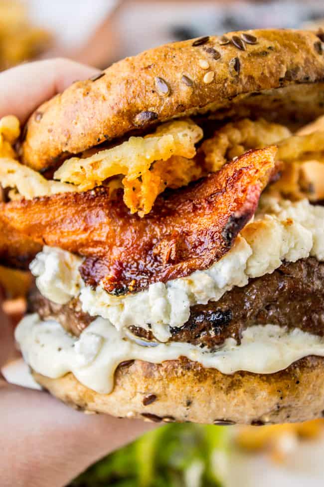Bacon and Goat Cheese Aioli Burger with Crispy Onions from The Food Charlatan. This juicy lemon aioli burger is topped with goat cheese, bacon, crispy onion strings, and a killer bun. It's a gourmet burger recipe that's perfect for any summer grilling get-togethers! #burger #aioli #grill #bacon #crispyonions #goatcheese #hamburgerbun #daveskillerbread #summer Bacon and Goat Cheese Aioli Burger
