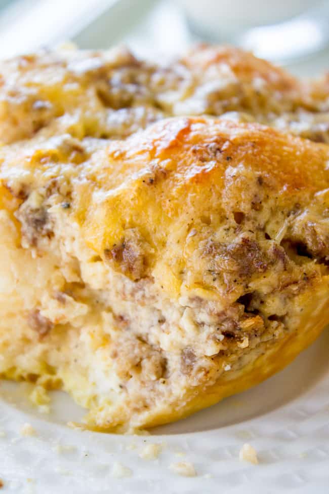 Overnight Biscuits and Gravy Casserole from The Food Charlatan. A quick and easy Biscuits and Gravy Casserole that you can make the night before! Just throw it in the oven in the morning. Use canned biscuits but homemade gravy. It is perfect for Christmas breakfast! #biscuits #gravy #breakfast #casserole #easy #overnight #makeahead #eggs #homemade biscuit and gravy breakfast casserole on a white plate.