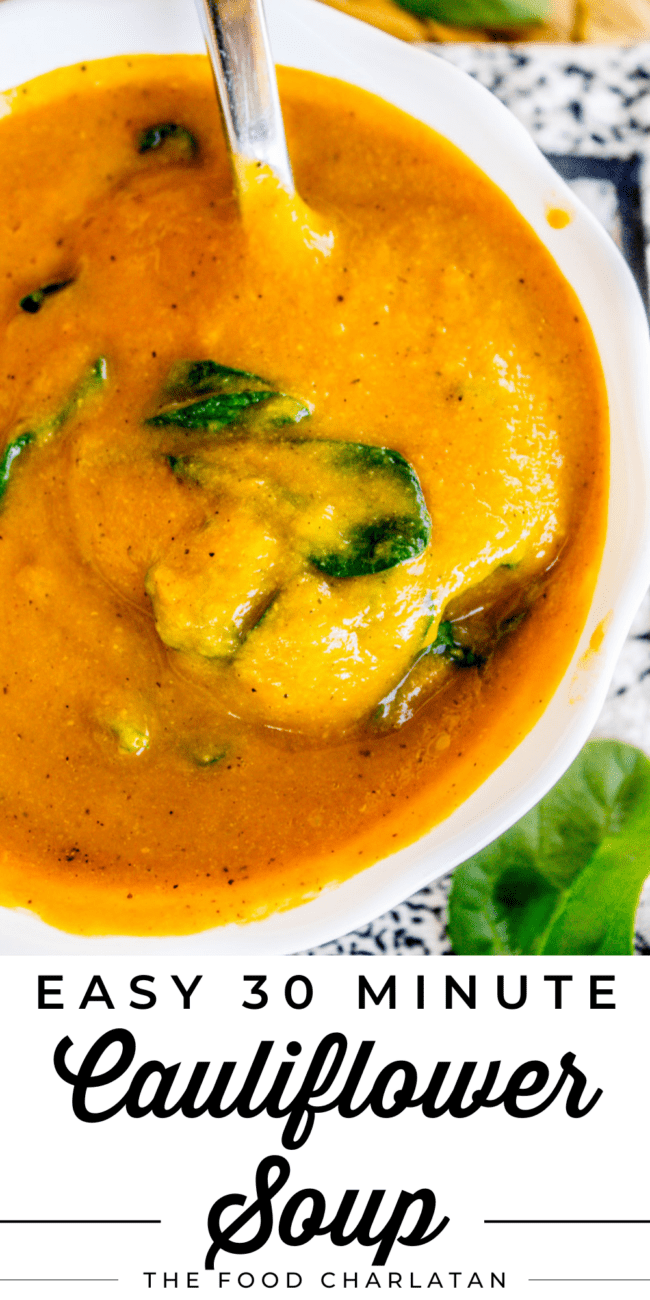 vegan cauliflower soup with spinach in a white bowl.