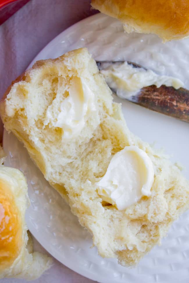 Dinner roll sliced with butter spread on it thickly.