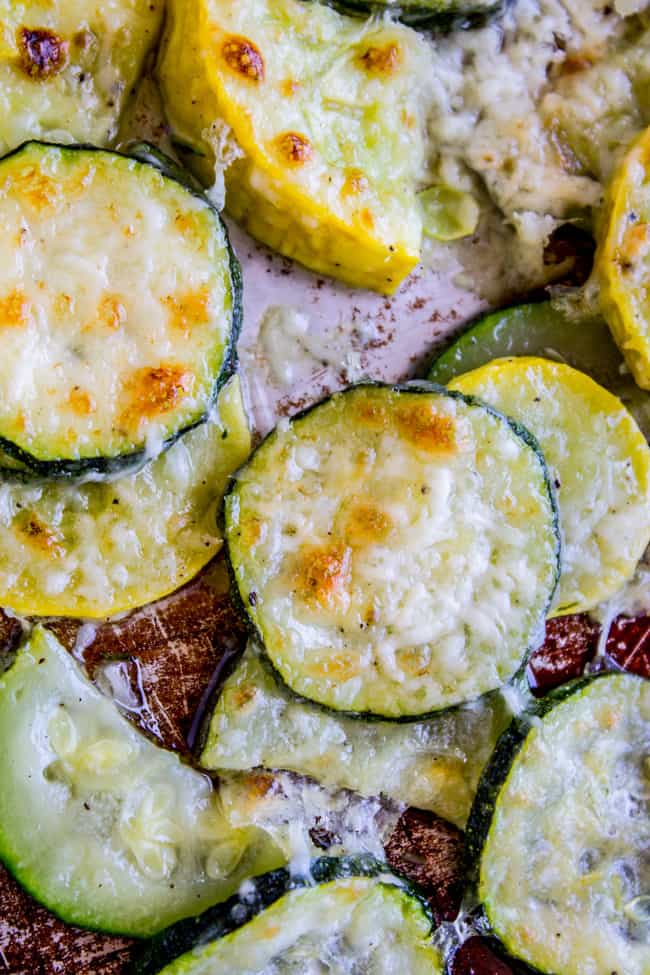 Yellow Squash and zucchini rounds on a pan, topped with crispy parmesan.