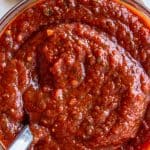 pizza sauce in a jar with a spoon.