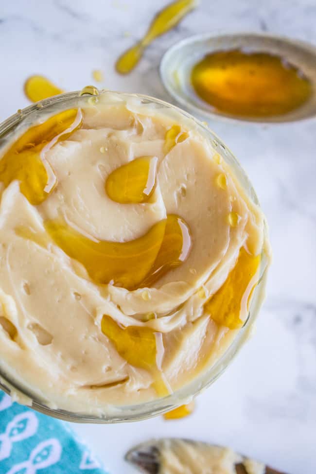 Maple butter in a glass jar with extra syrup on a spoon. 