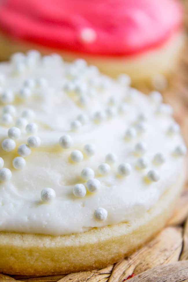 Sugar cookie frosting recipe in white on a cookie with sprinkles.