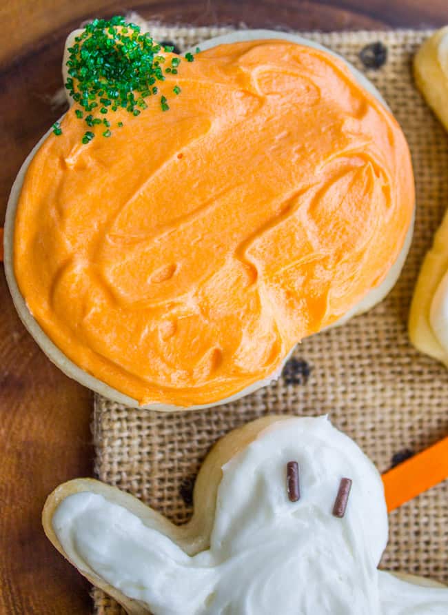 Orange-frosted Halloween soft sugar cookie with green sprinkles.