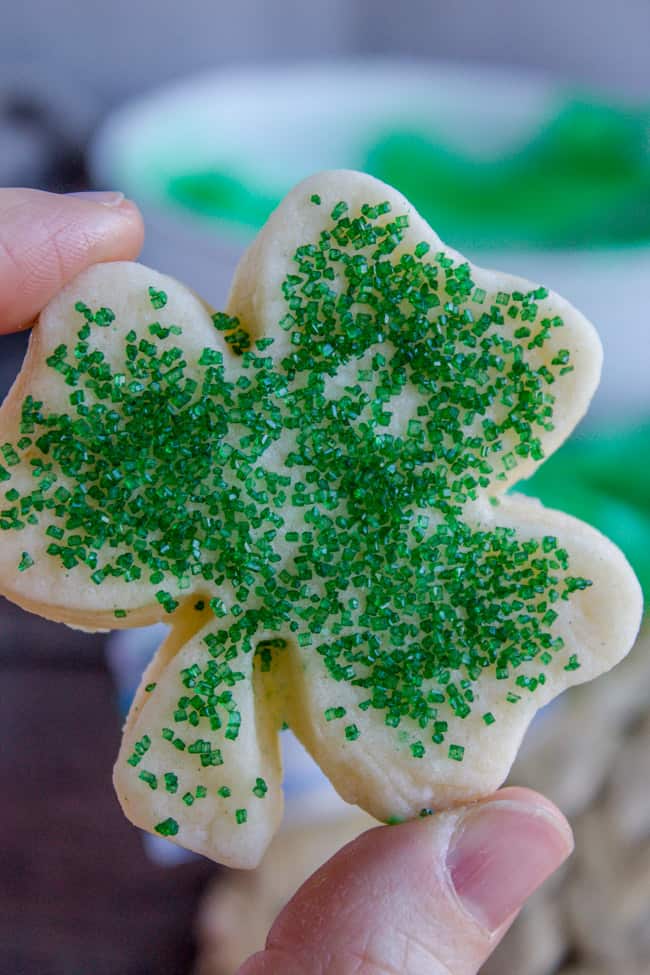 Sugar cookie showing unfrosted shamrock-shaped cookie with green sprinkles.