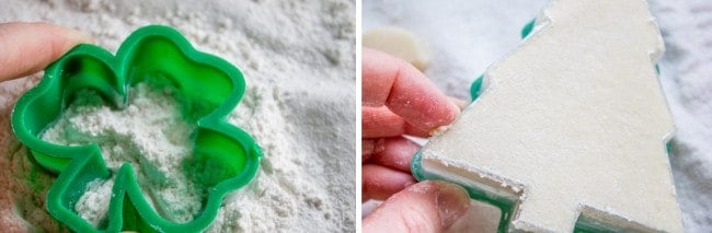a plastic shamrock-shaped cookie cut out next to Soft Sugar Cookie dough in the shape of a Christmas tree.