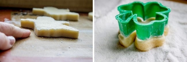 sugar cookie dough in the shape of a Christmas tree on a pan next to a plastic cut-out trimming shamrock-shaped dough. 