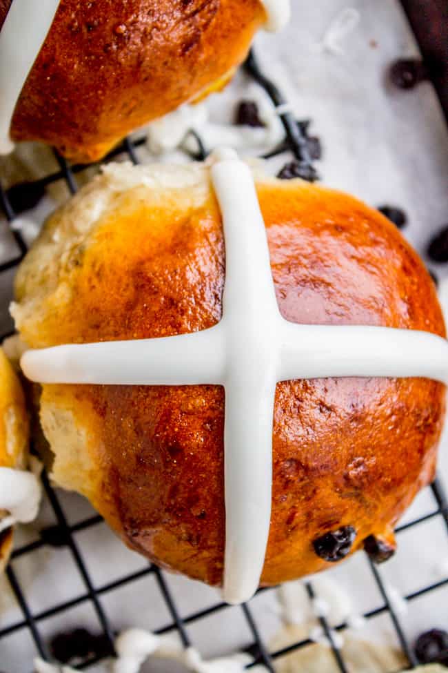 a hot cross bun on a cooling rack.