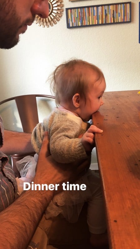 baby biting a table.