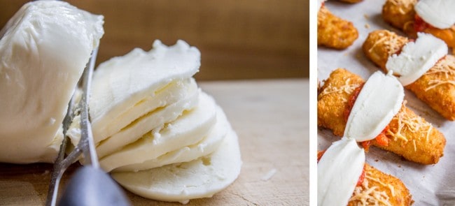 Sliced fresh mozzarella with a knife and mozzarella on top of fish sticks with tomato sauce. 