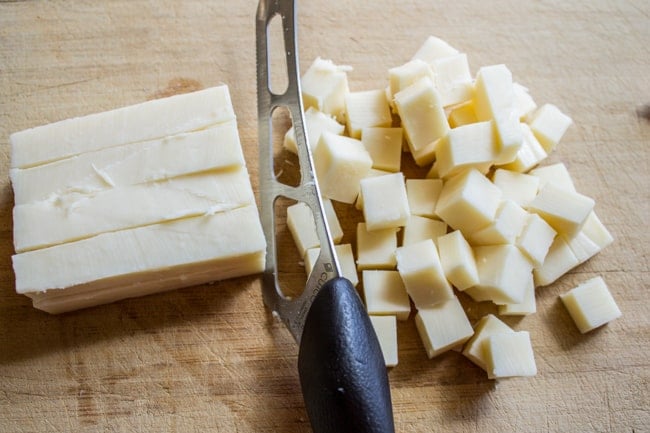a block of mozzarella cheese cut into cubes.