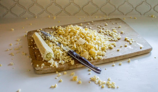 Cutting the corn off of each cob.