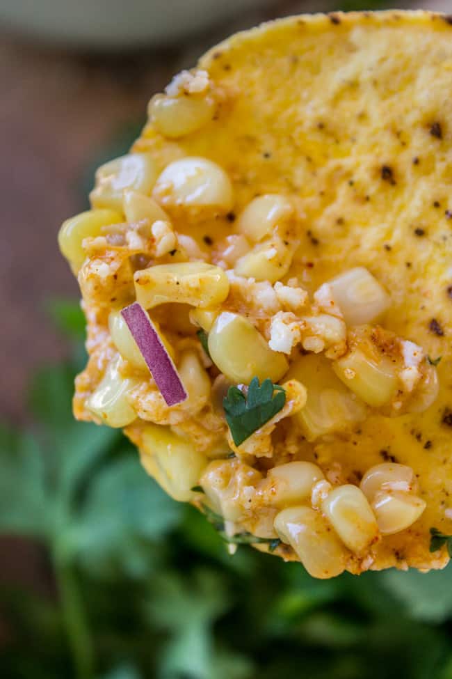 Close up of elote dip on a tortilla chip. 