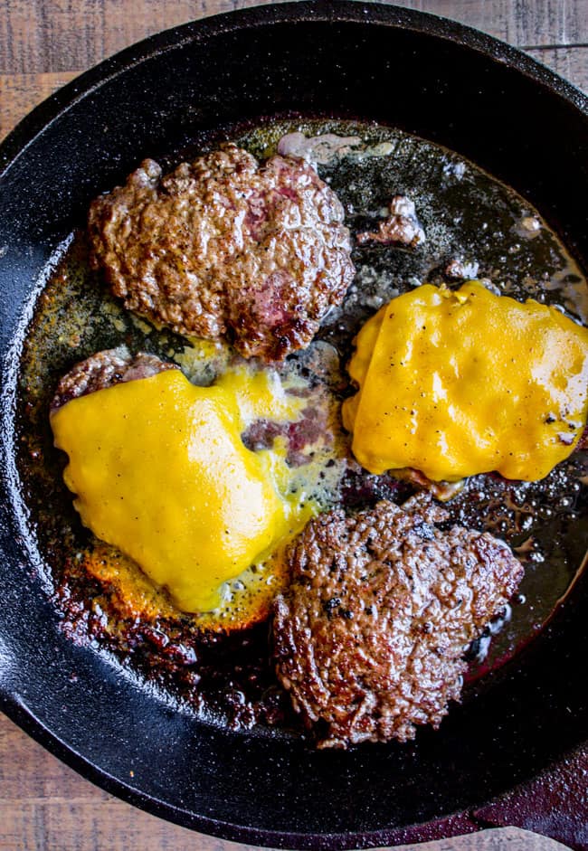 burgers, with and without cheese, in a cast iron skillet.