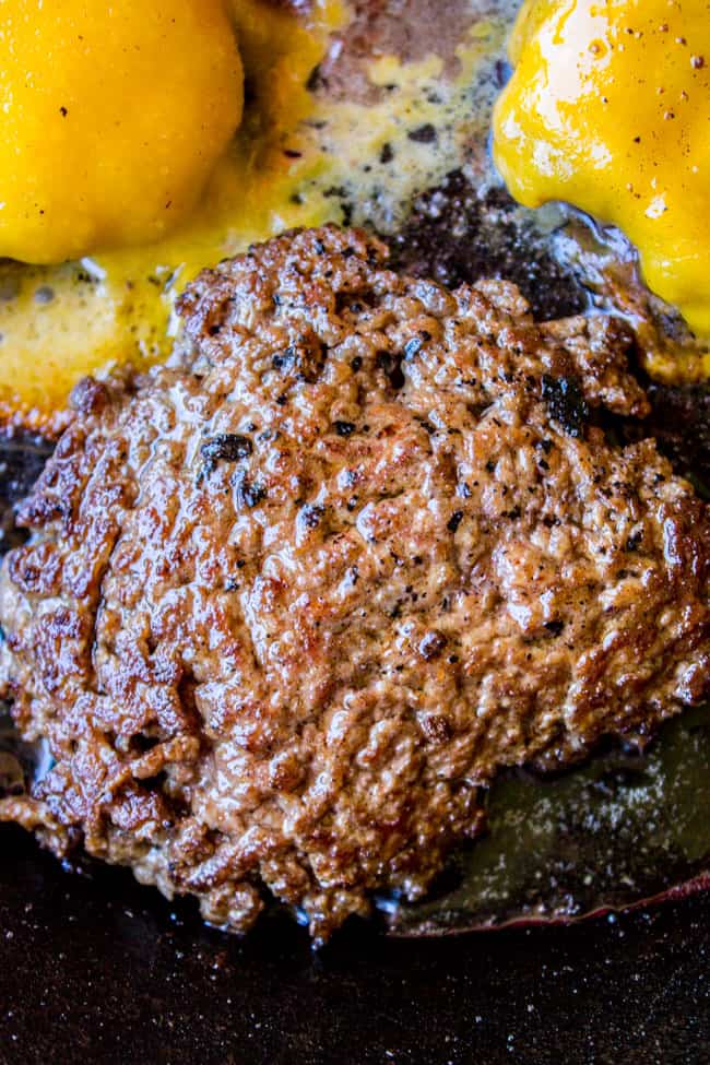 close up of a burger, burgers with melted cheese in the background.