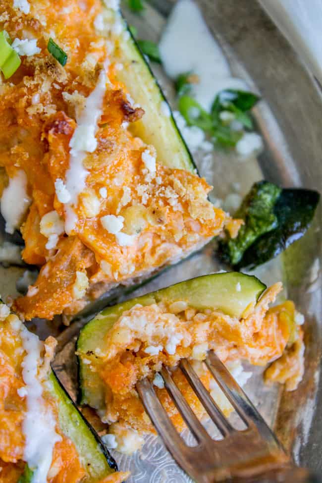 A fork and a bite of buffalo chicken zucchini boats, ready to eat.