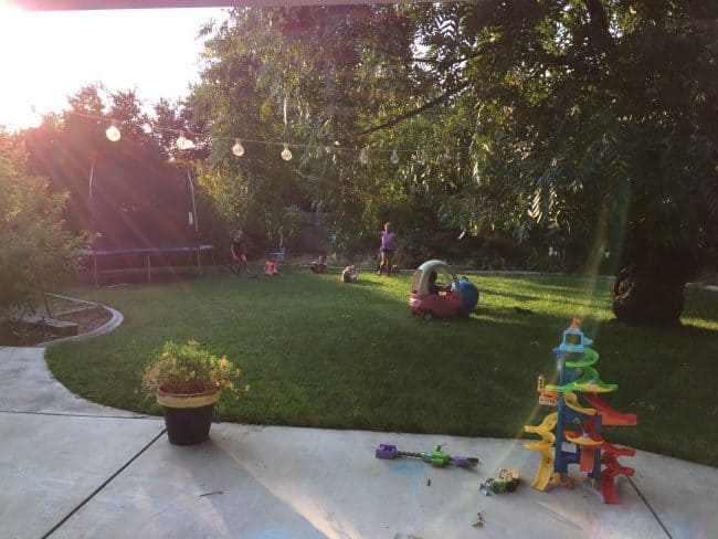 A backyard with toys and children playing. 