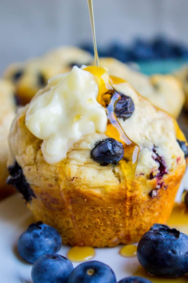 Blueberry Buttermilk Pancake Muffins with Maple Syrup being drizzled on top.
