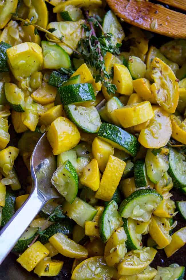 sauteed zucchini and squash with thyme and a wooden spoon. 