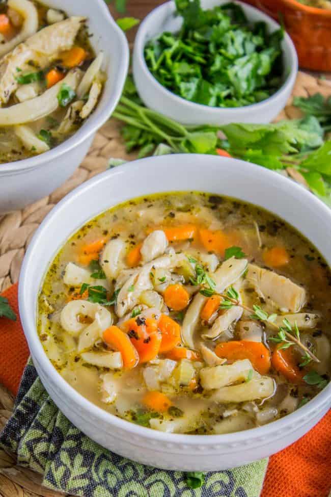 Chicken Noodle Soup with Homemade Noodles from The Food Charlatan. Is there anything more comforting than homemade Chicken Noodle Soup? Carrots, onions, celery...the smell is enough to bring you back. This recipe uses dark and white meat from a rotisserie chicken, and homemade noodles (or you can totally use store-bought). It's nostalgia in a bowl! #chicken #noodles #homemade #soup #comfortfood #healthy #easy #carrots #celery #rotisserie bowls of homemade chicken noodle soup.