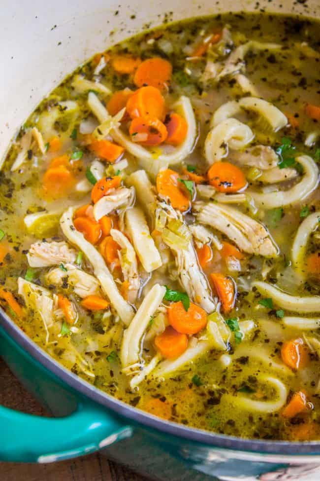 Chicken Noodle Soup with Homemade Noodles from The Food Charlatan. Is there anything more comforting than homemade Chicken Noodle Soup? Carrots, onions, celery...the smell is enough to bring you back. This recipe uses dark and white meat from a rotisserie chicken, and homemade noodles (or you can totally use store-bought). It's nostalgia in a bowl! #chicken #noodles #homemade #soup #comfortfood #healthy #easy #carrots #celery #rotisserie Chicken noodle soup with homemade noodles in a pot.