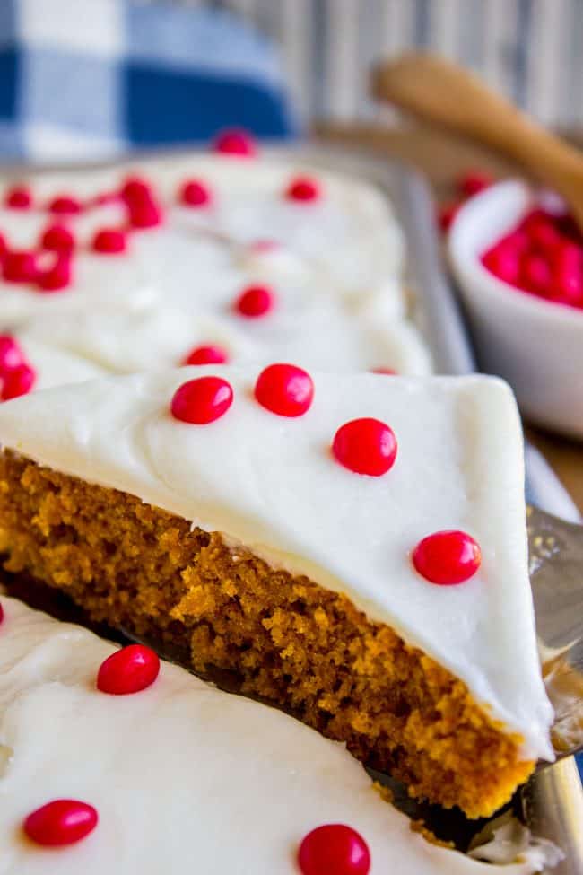 a slice of pumpkin bars topped with cream cheese frosting and red hots.