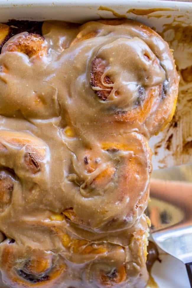 Pumpkin Cinnamon Rolls with Caramel Cream Cheese Frosting in a white baking dish.