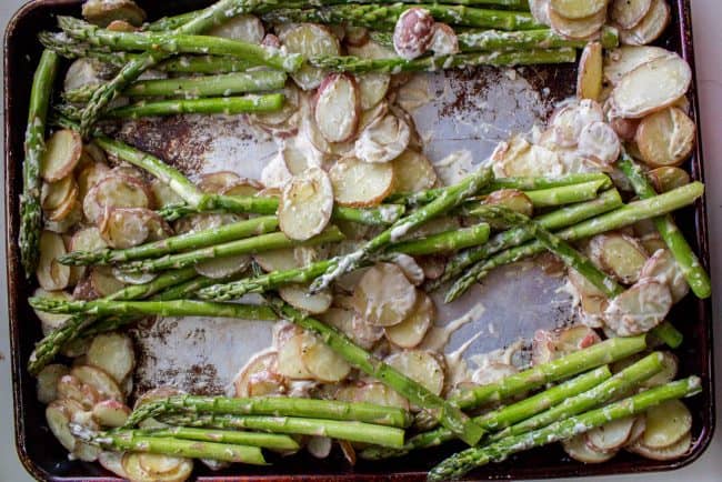 Sheet Pan Salmon with Creamy Scalloped Potatoes and Asparagus from The Food Charlatan. Don't you just love sheet pan dinners?? They are so easy and there's only ONE DISH to wash! This Citrus Herb Salmon is paired with creamy scalloped potatoes and fresh asparagus to make a super easy, pretty healthy, and DELICIOUS one pan meal. #dinner #asparagus #sheetpan #onepan #salmon #lemon #healthy #roastedsalmon #easy #quick #herb #potatoes #creamy #recipe #mealprep #weeknight #salmonrecipesbaked #salmondinner #onesheetpanmeals #sheetpanmeals Sheet pan asparagus and potato bake