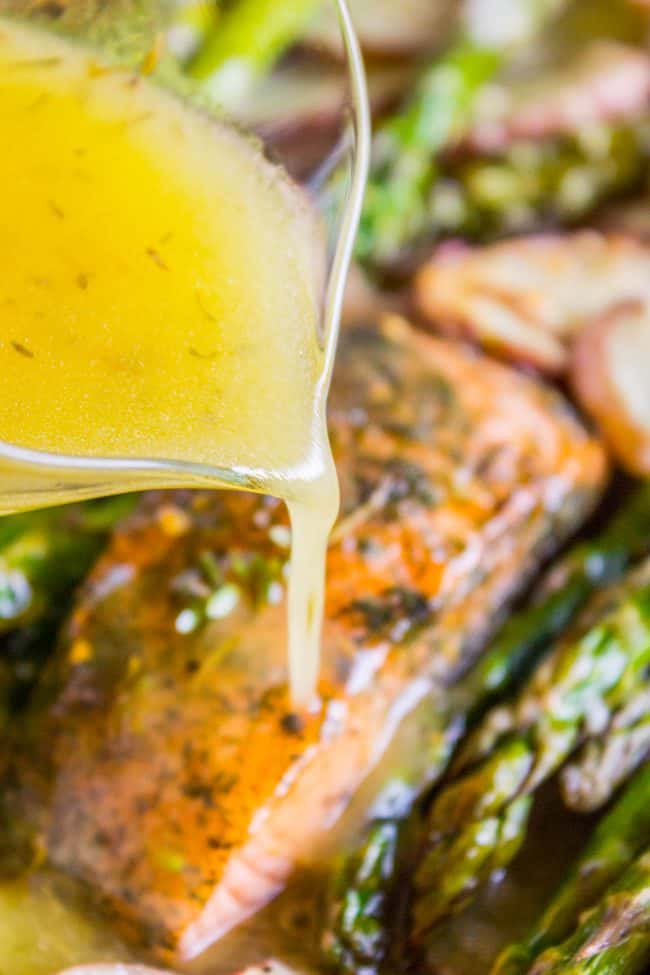 Sheet Pan Salmon with Creamy Scalloped Potatoes and Asparagus from The Food Charlatan. Don't you just love sheet pan dinners?? They are so easy and there's only ONE DISH to wash! This Citrus Herb Salmon is paired with creamy scalloped potatoes and fresh asparagus to make a super easy, pretty healthy, and DELICIOUS one pan meal. #dinner #asparagus #sheetpan #onepan #salmon #lemon #healthy #roastedsalmon #easy #quick #herb #potatoes #creamy #recipe #mealprep #weeknight #salmonrecipesbaked #salmondinner #onesheetpanmeals #sheetpanmeals Lemon sauce on salmon asparagus and potatoes