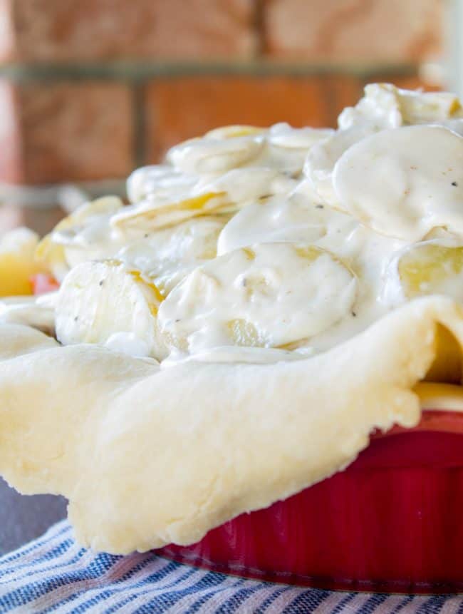 scalloped potatoes in pie in a red pie pan.
